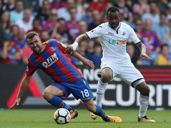 Crystal Palace and Swansea players compete in a Premier League Match